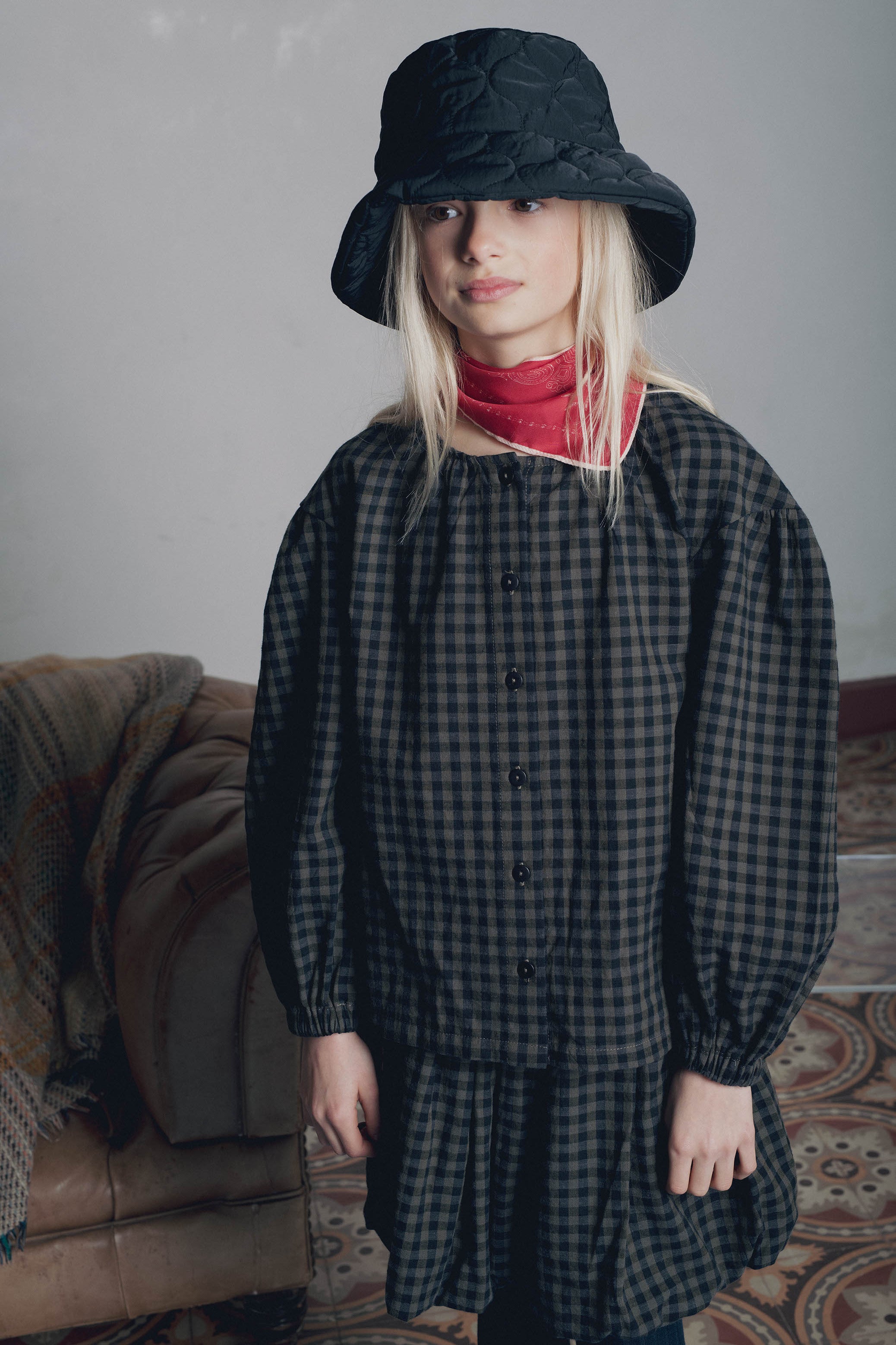 Portrait fillette portant bob noir foulard rouge et blouse à carreaux Marlot Paris.