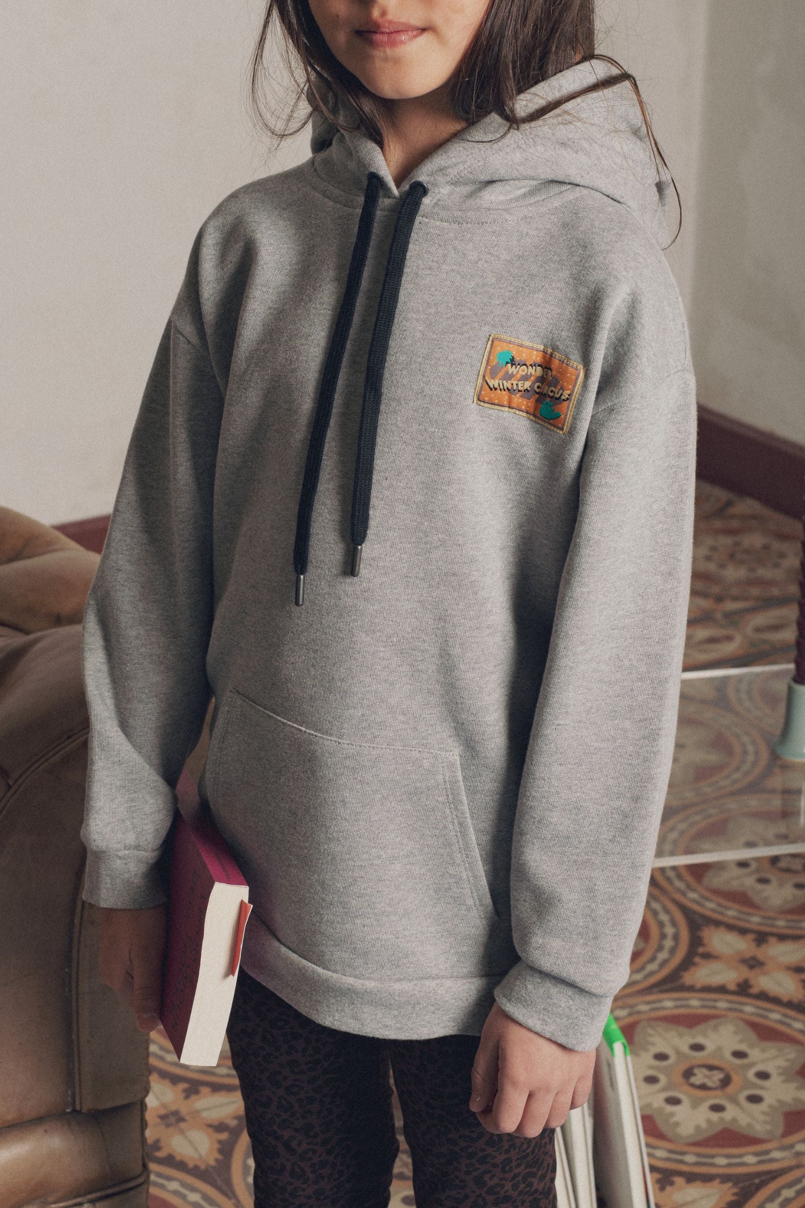 Détail encolure et écusson sweat enfant à capuche gris Marlot Paris.