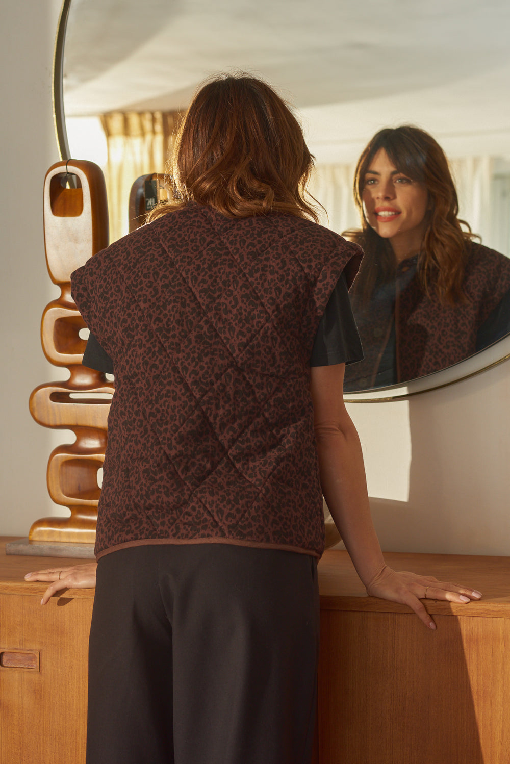 Vue de dos gilet léopard Marlot Paris femme se regardant dans miroir rond.