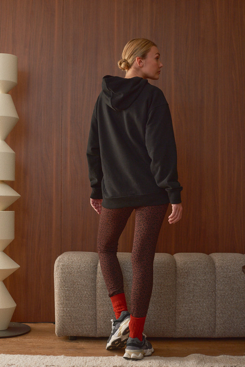 Silhouette femme vue de dos sweat capuche noir et legging léopard Marlot Paris
