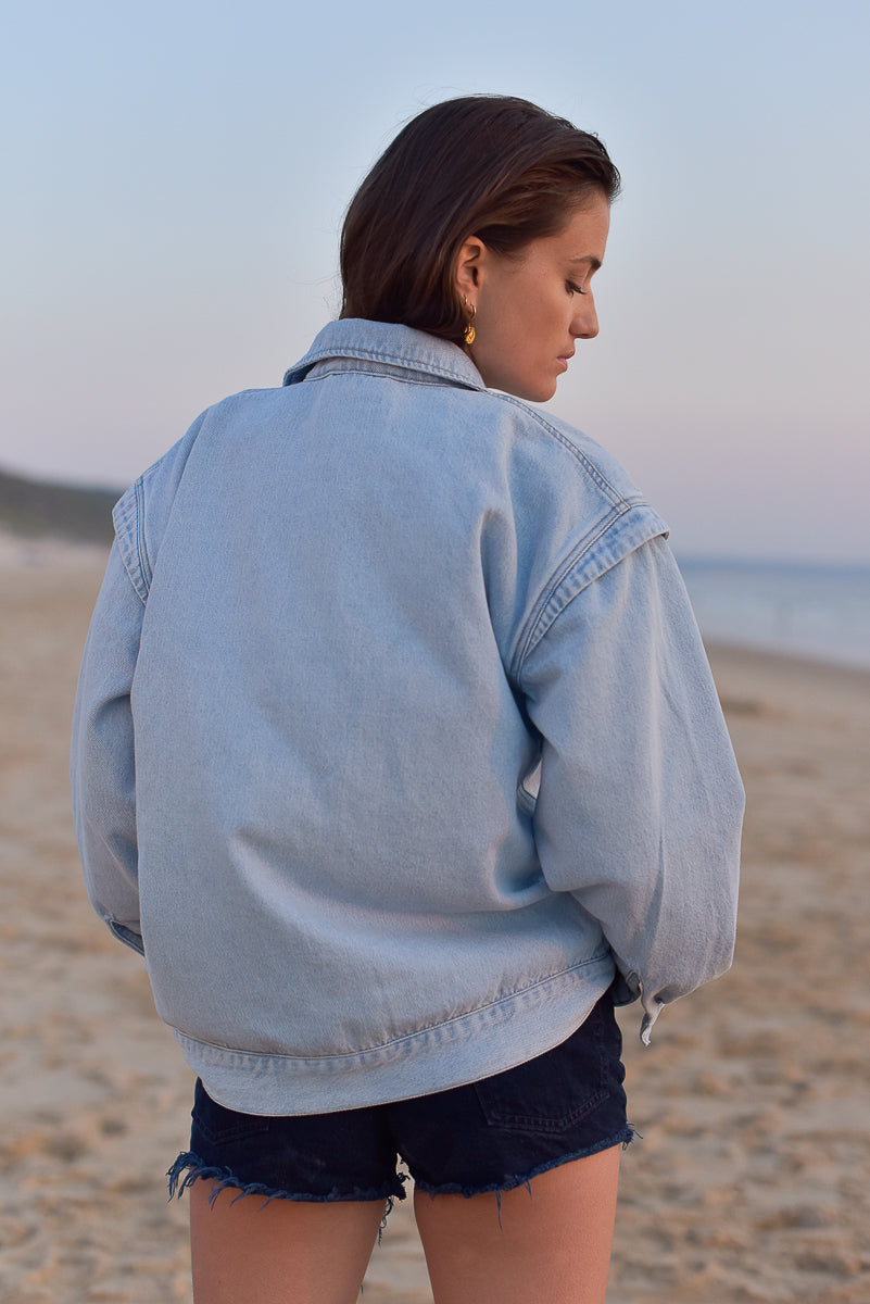vue de dos veste jeans femme marlot paris paysage plage