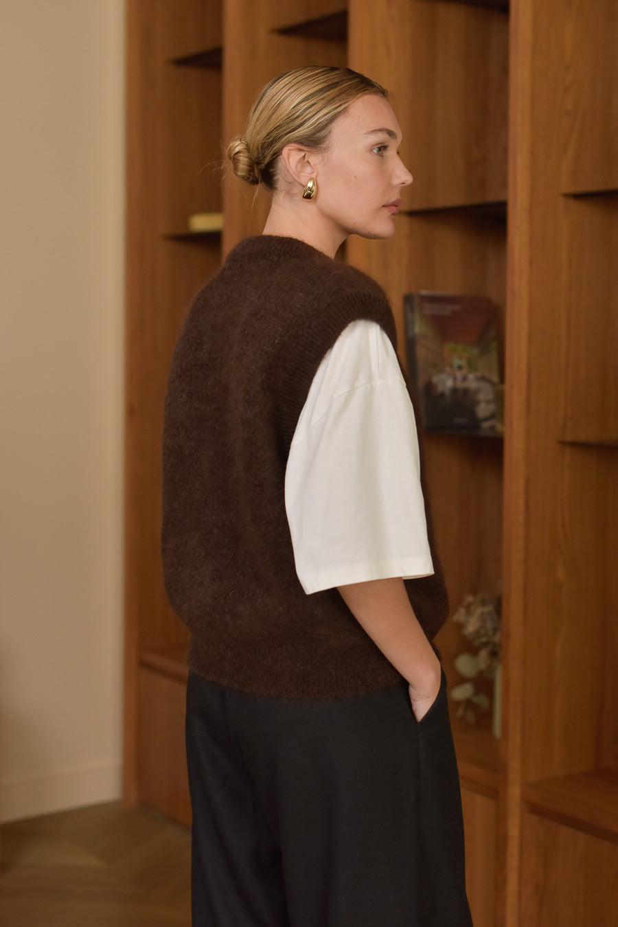 Femme vue de trois quart dos portant gilet sans manches couleur chocolat Marlot Paris.