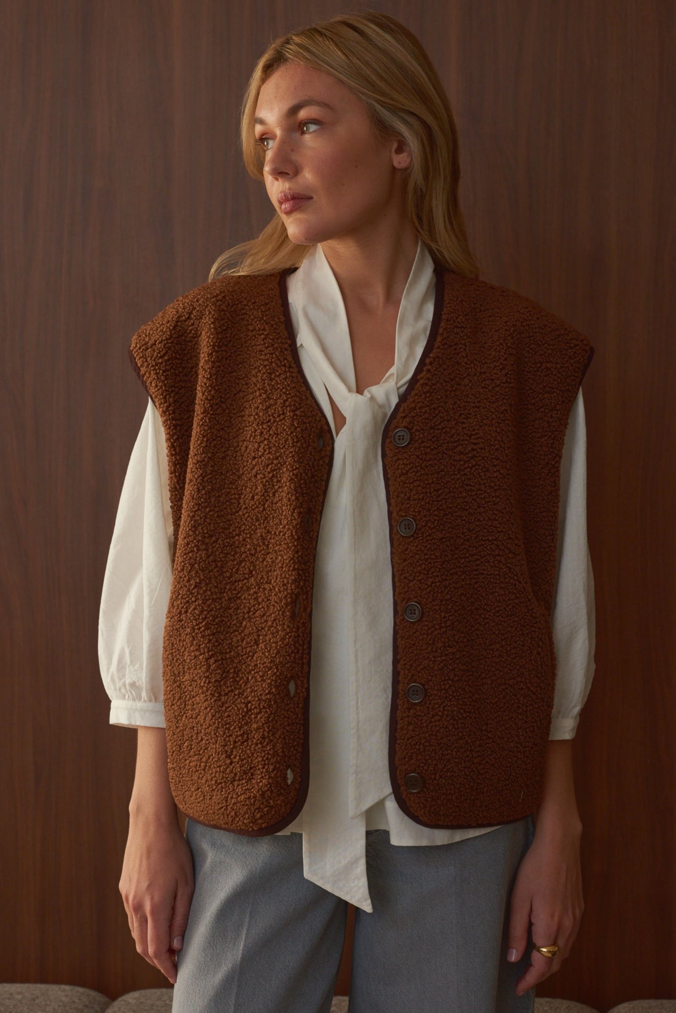 Portrait femme portant gilet moumoute sans manche couleur chocolat Marlot Paris.