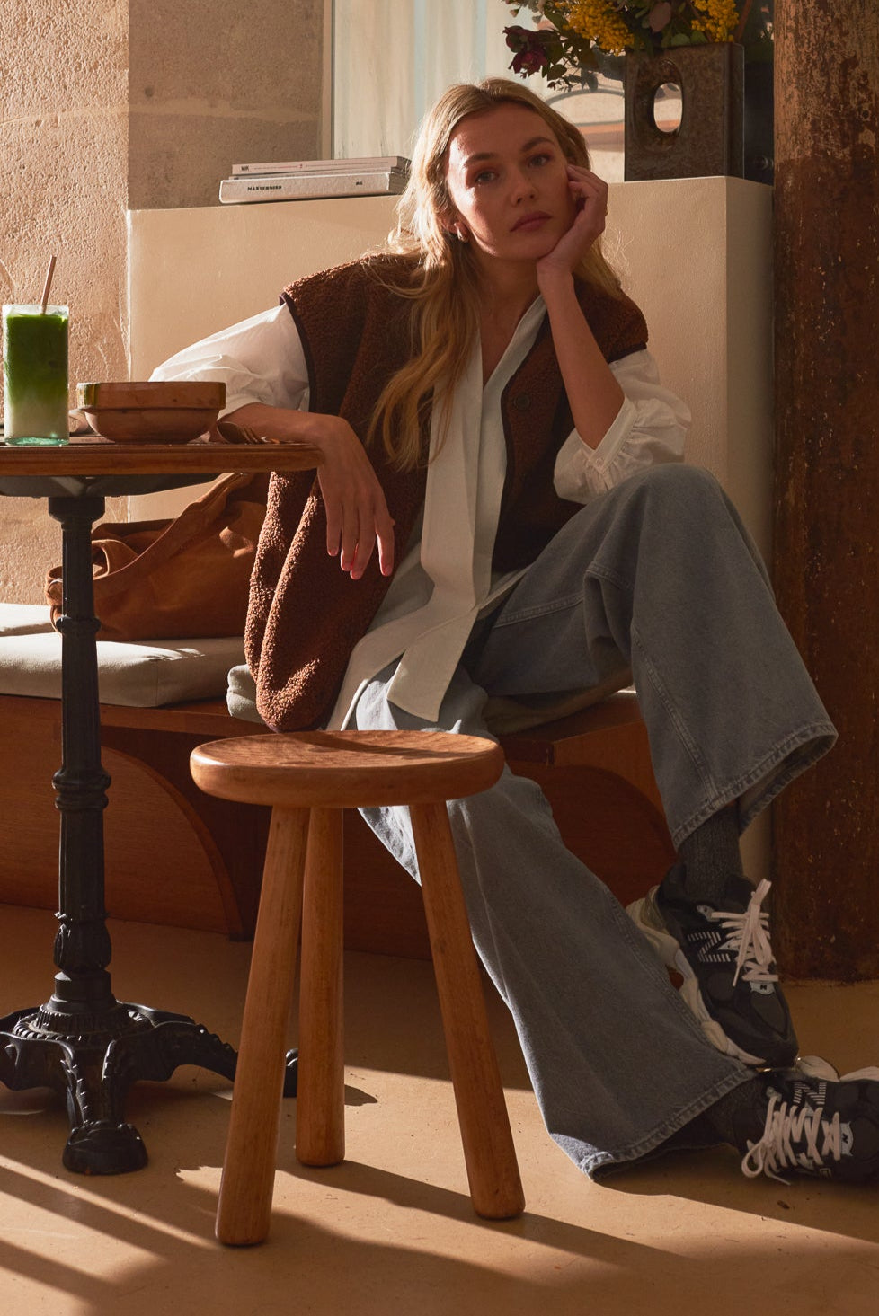 Portrait femme café portant chemise cléra blanche Marlot Paris et gilet moumoute