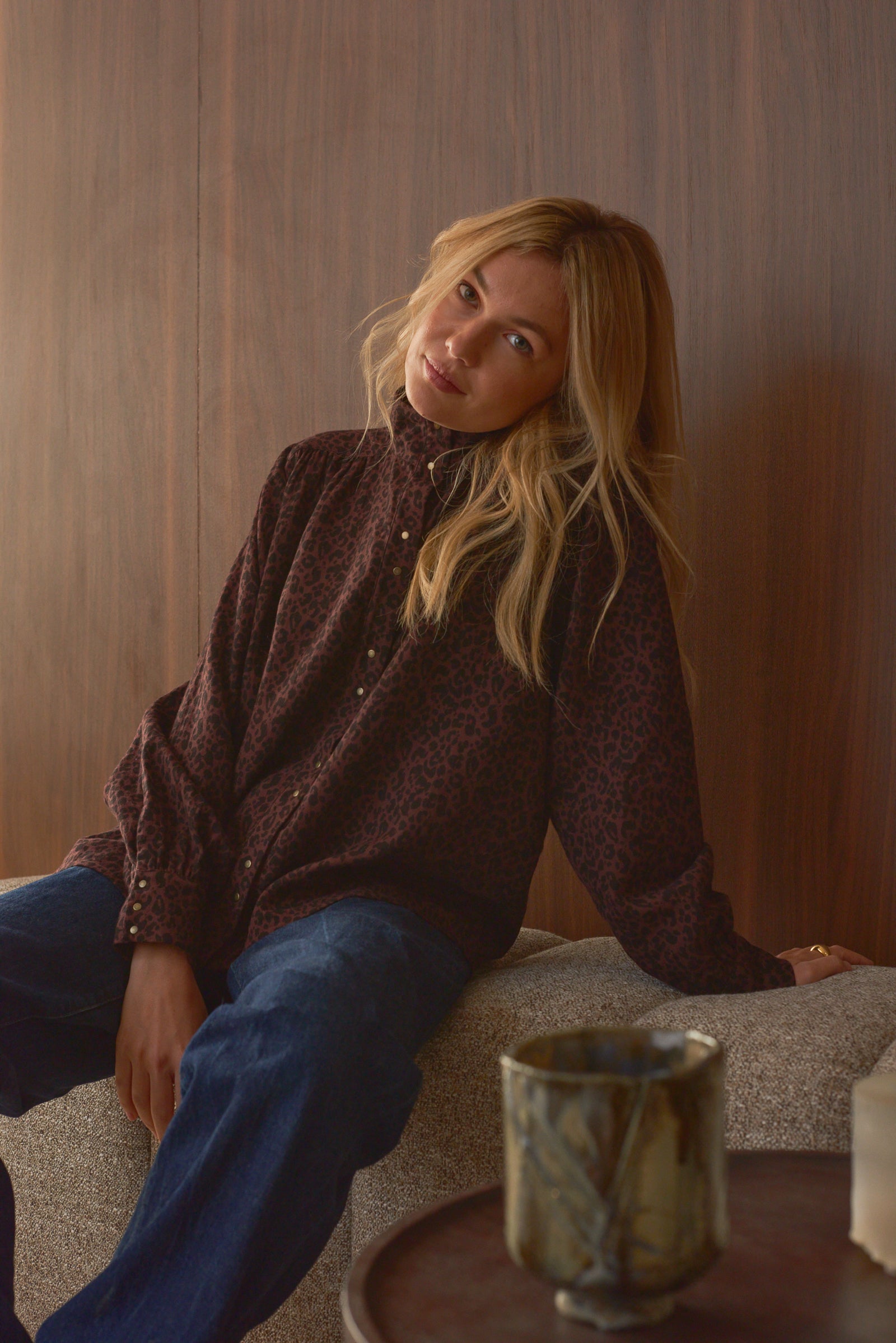 Portrait femme assise look chemise léopard et jean Marlot Paris