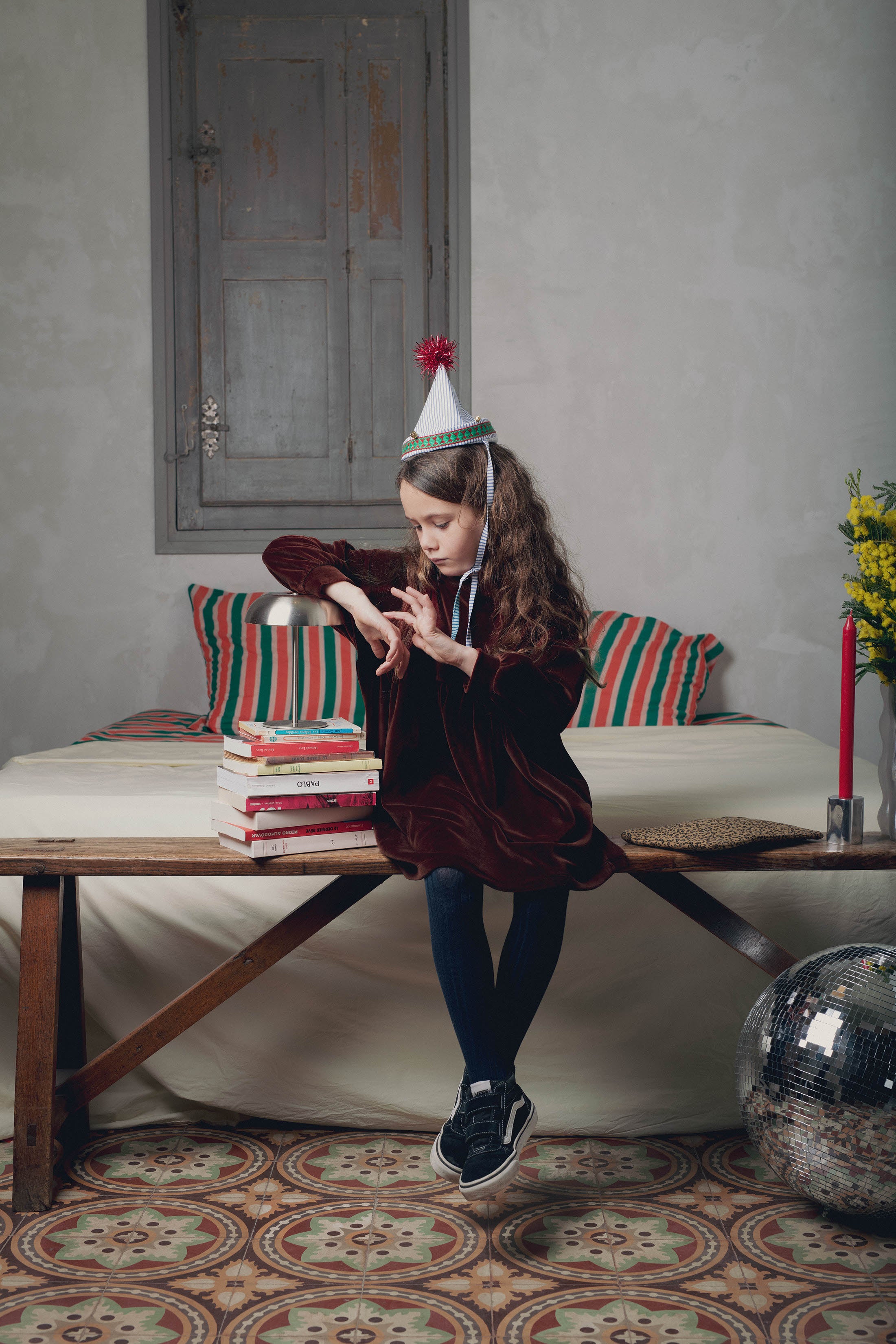 Fillette assise sur banc robe velours marron Marlot Paris boule disco