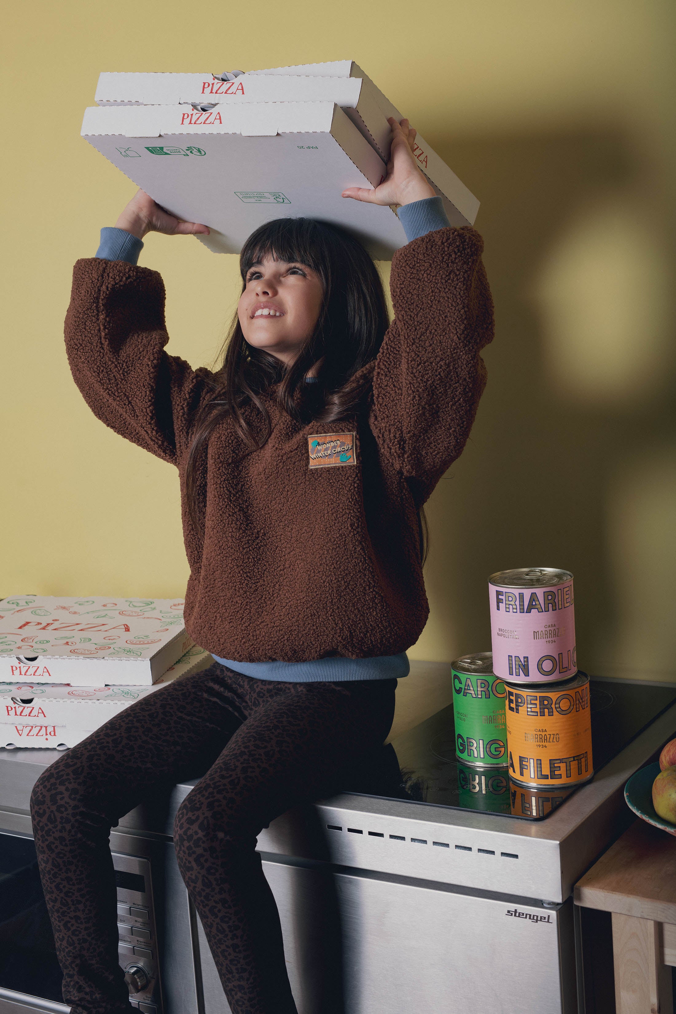 Fillette portant sweat moumoute marron Marlot Paris portant boites de pizzas