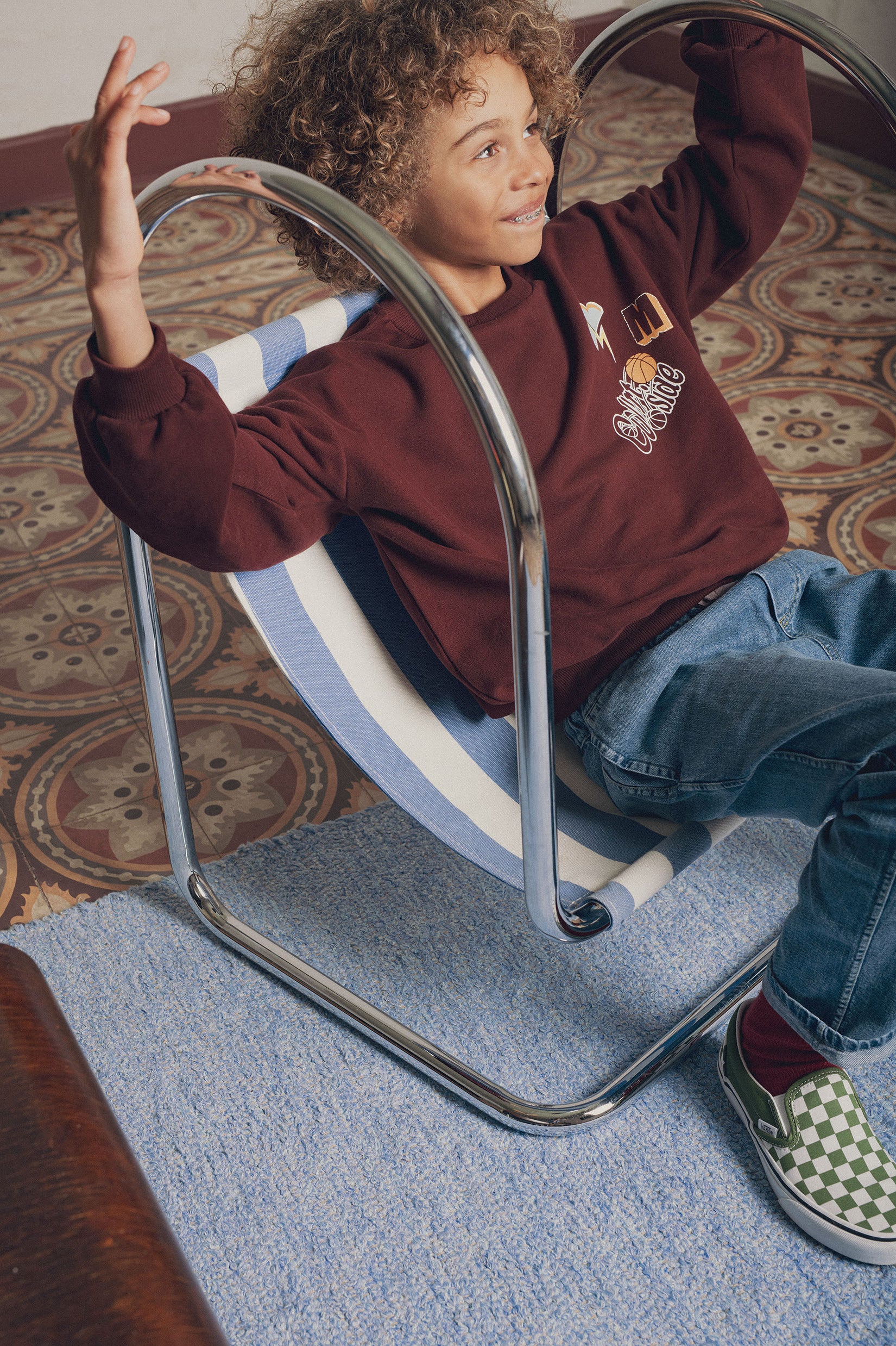 Portrait garçon portant sweat maxime brun Marlot Paris dans fauteuil design