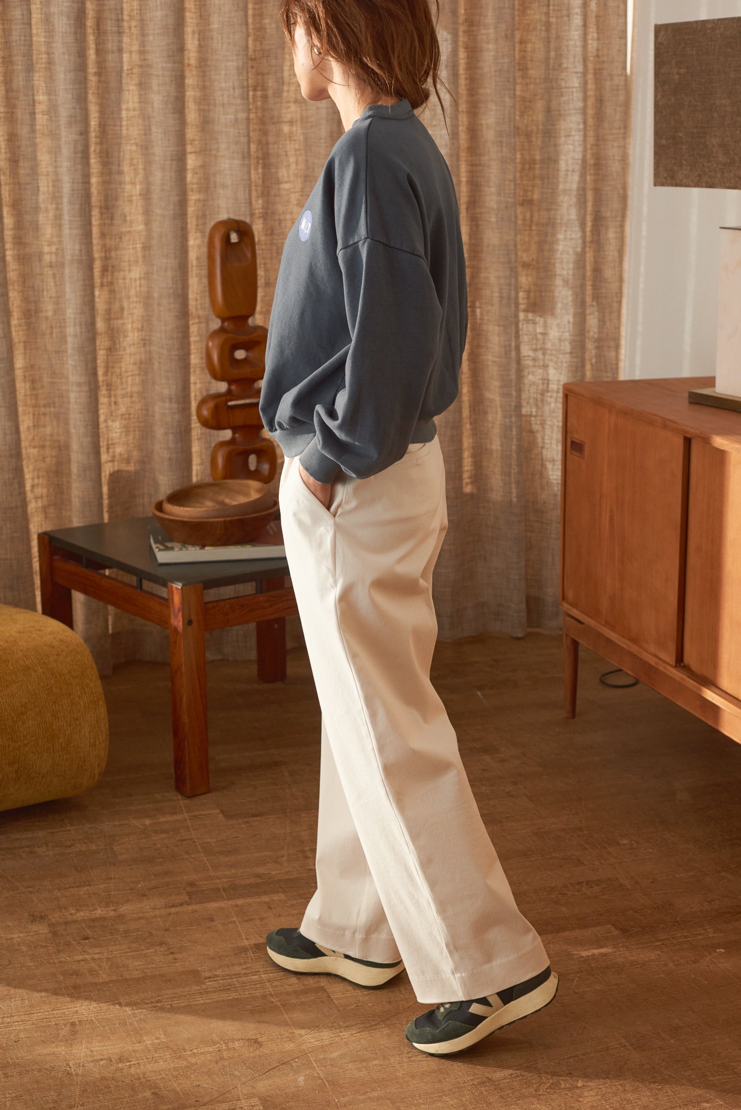 Vue de profil en marche pantalon écru femme Nino Marlot Paris.