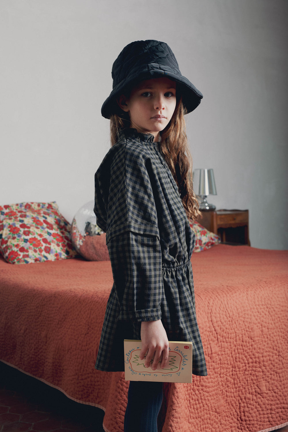Vue de profil fillette portant robe vichy kaki Marlot Paris avec bob et livre