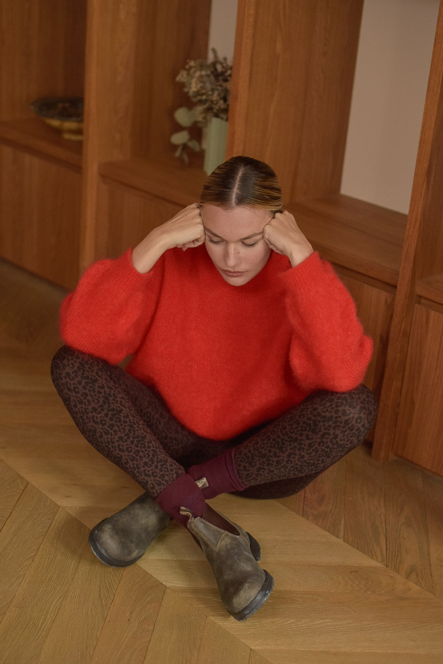 Femme assise genoux croisés pull rouge mohair legging léopard Marlot Paris.
