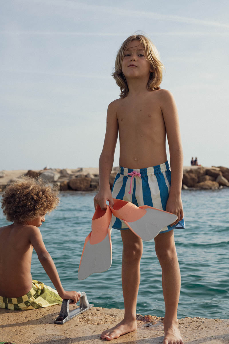 garçon portant short de bain rayé bleu marlot paris et palmes