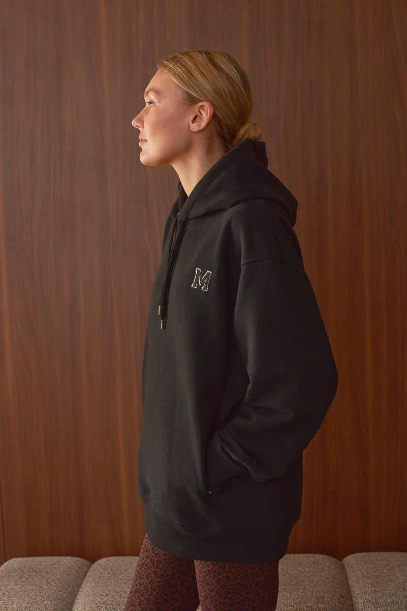 Vue de profil hoodie noir femme Marlot Paris mains dans les poches