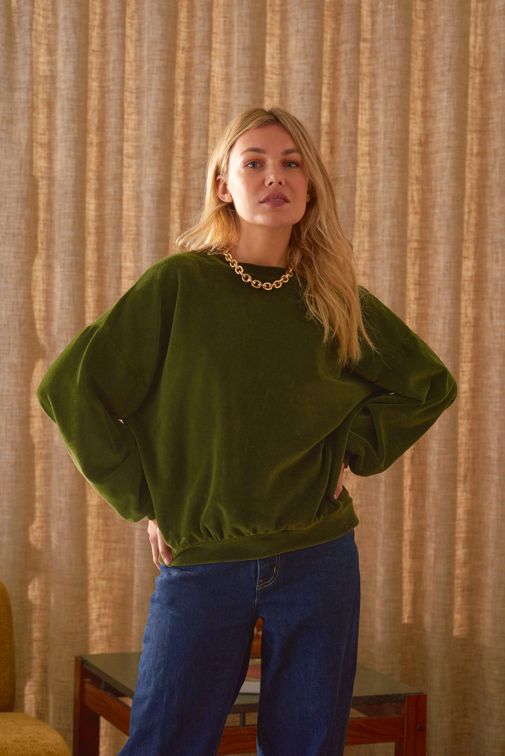 Look femme sweat velours vert Marlot Paris mains sur les hanches collier or. 