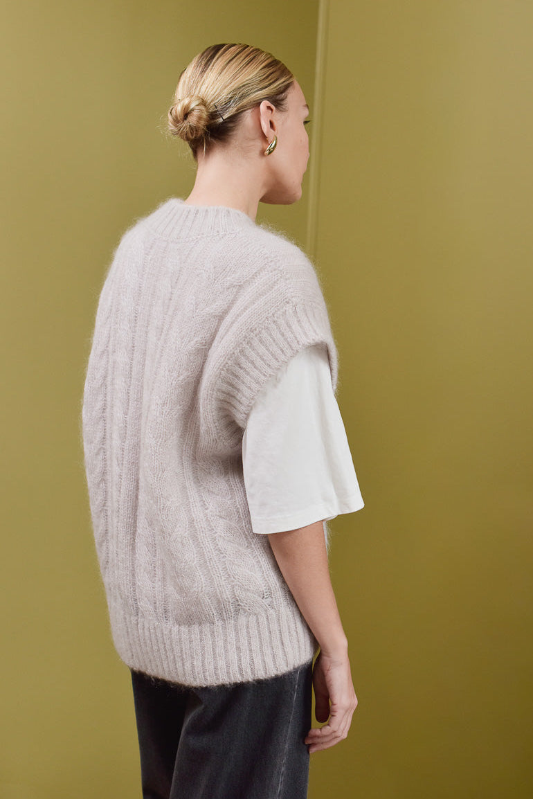 Vue de trois quart dos femme portant pull sans manche beige Marlot Paris. 