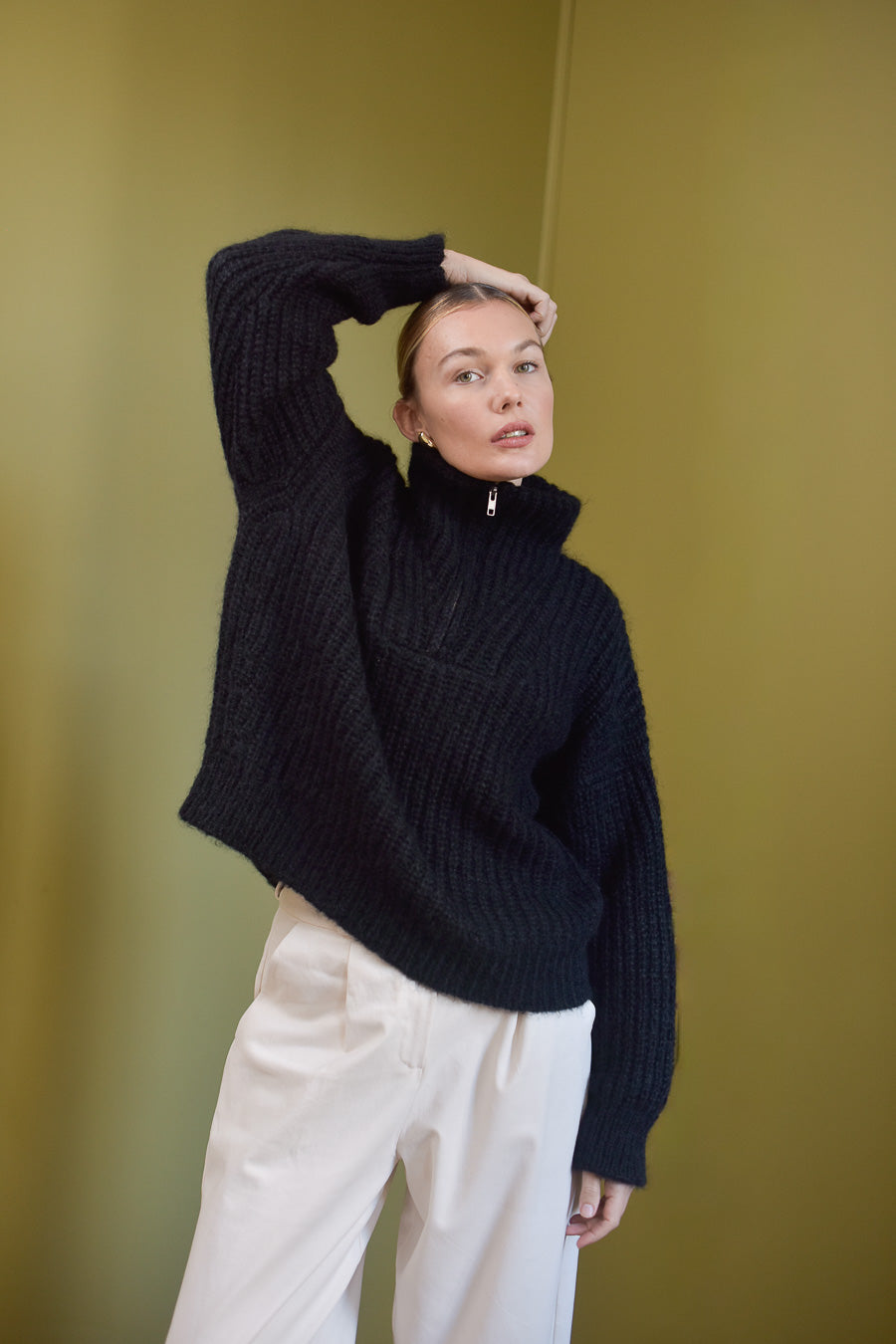 Portrait femme pull noir camionneur Marlot Paris et pantalon blanc.