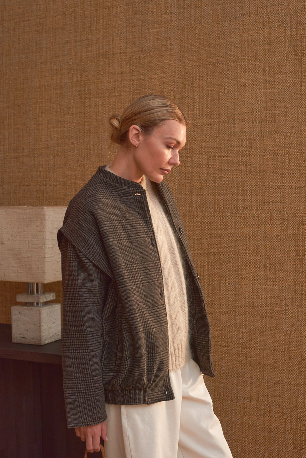 Portrait femme manteau court carreaux gris Marlot Paris porté ouvert sur pull blanc.